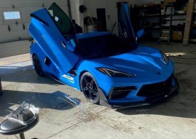 Blue sportscar with doors open and glossy paint