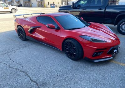Red sportscar with spoiler and tinted windows view from side